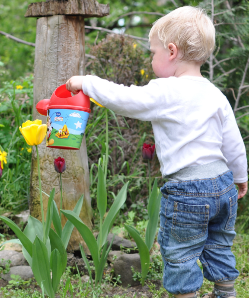 Kind mit langen Hosen im Garten.